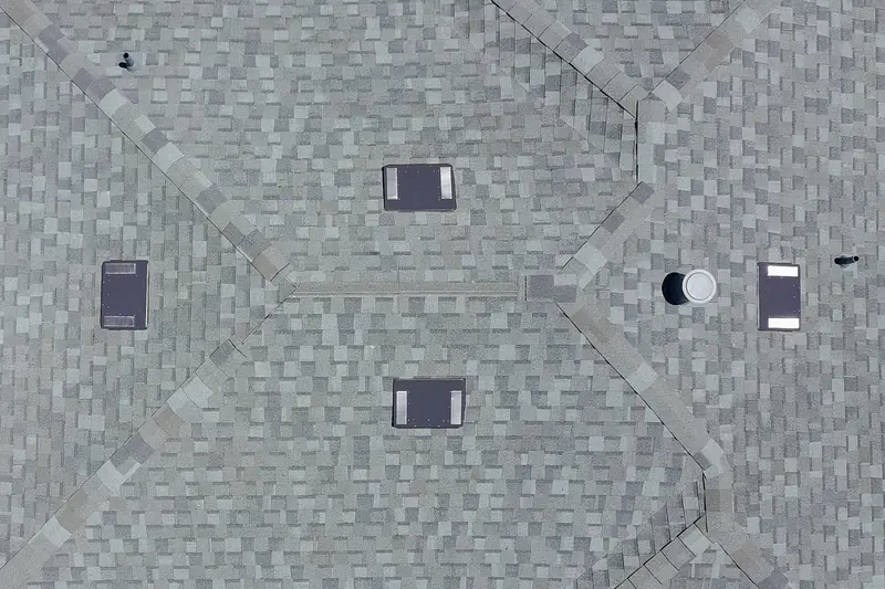 Aerial view of a gray shingle roof with low-profile attic vents