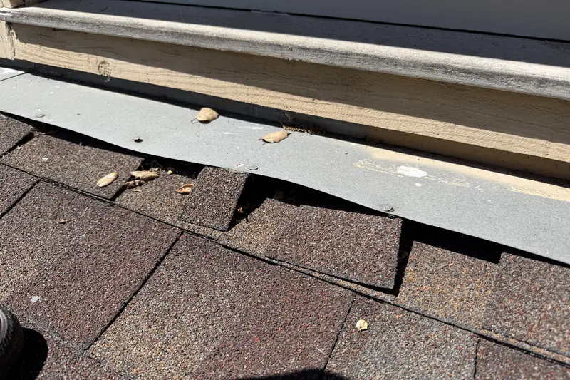 Old metal flashing pulling away where a roof meets a wall