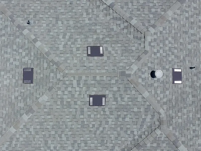 Aerial view of a gray shingle roof with low-profile attic vents